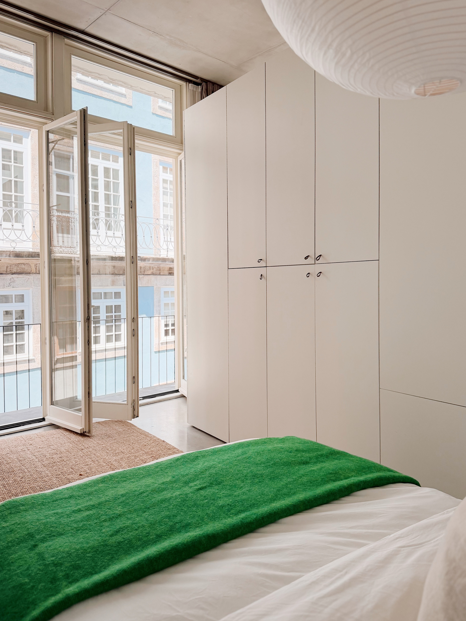 Balcony doors open in the bedroom area.