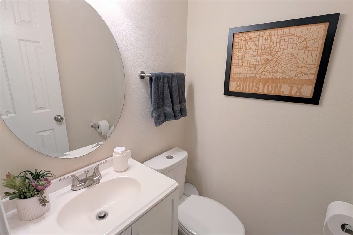 Convenient half bath is located near the downstairs living space and is stocked with foaming hand soap, fluffy towels, and water efficient toilet.