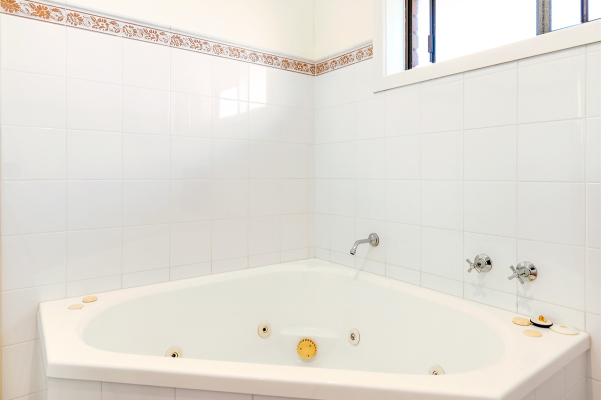 A corner spa bath gives the upstairs main bathroom a standout feature within the main-level layout at Bertie’s 3 beaches.