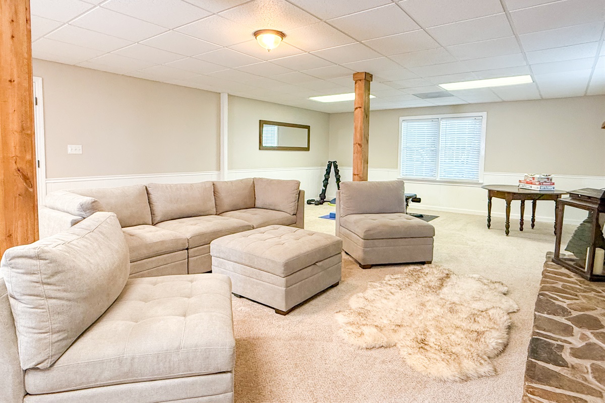 The basement features a large sectional sofa and a smart TV, providing an additional space to gather.
