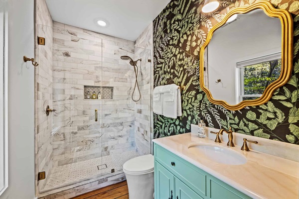 The primary bath design is inspired by nature and features botanical wallpaper. 