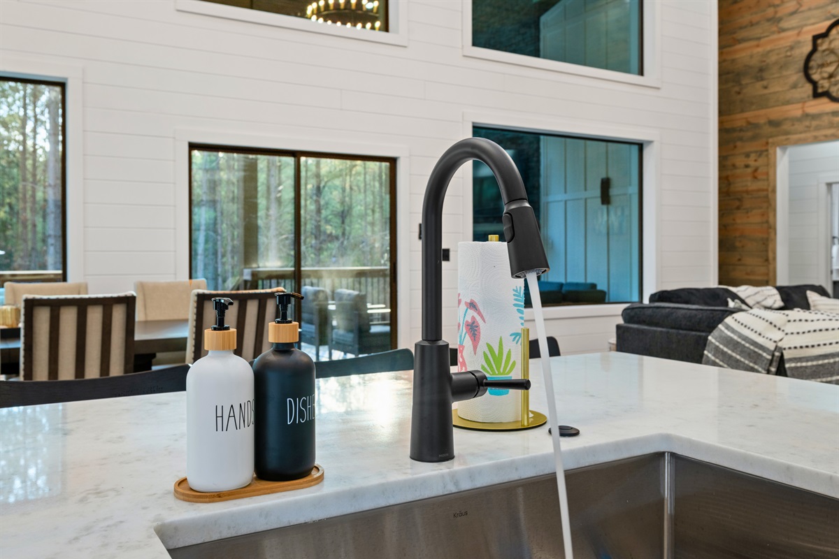 The large farmhouse sink and spacious counters make cleanup simple while still keeping you connected to the open living area.