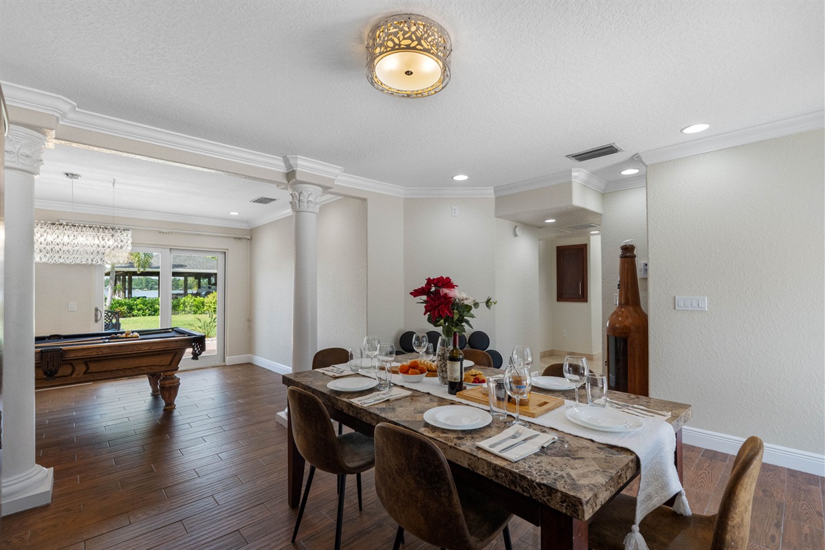 The dining space flows seamlessly into the game and kitchen areas, making it perfect for hosting large gatherings and dinner parties.