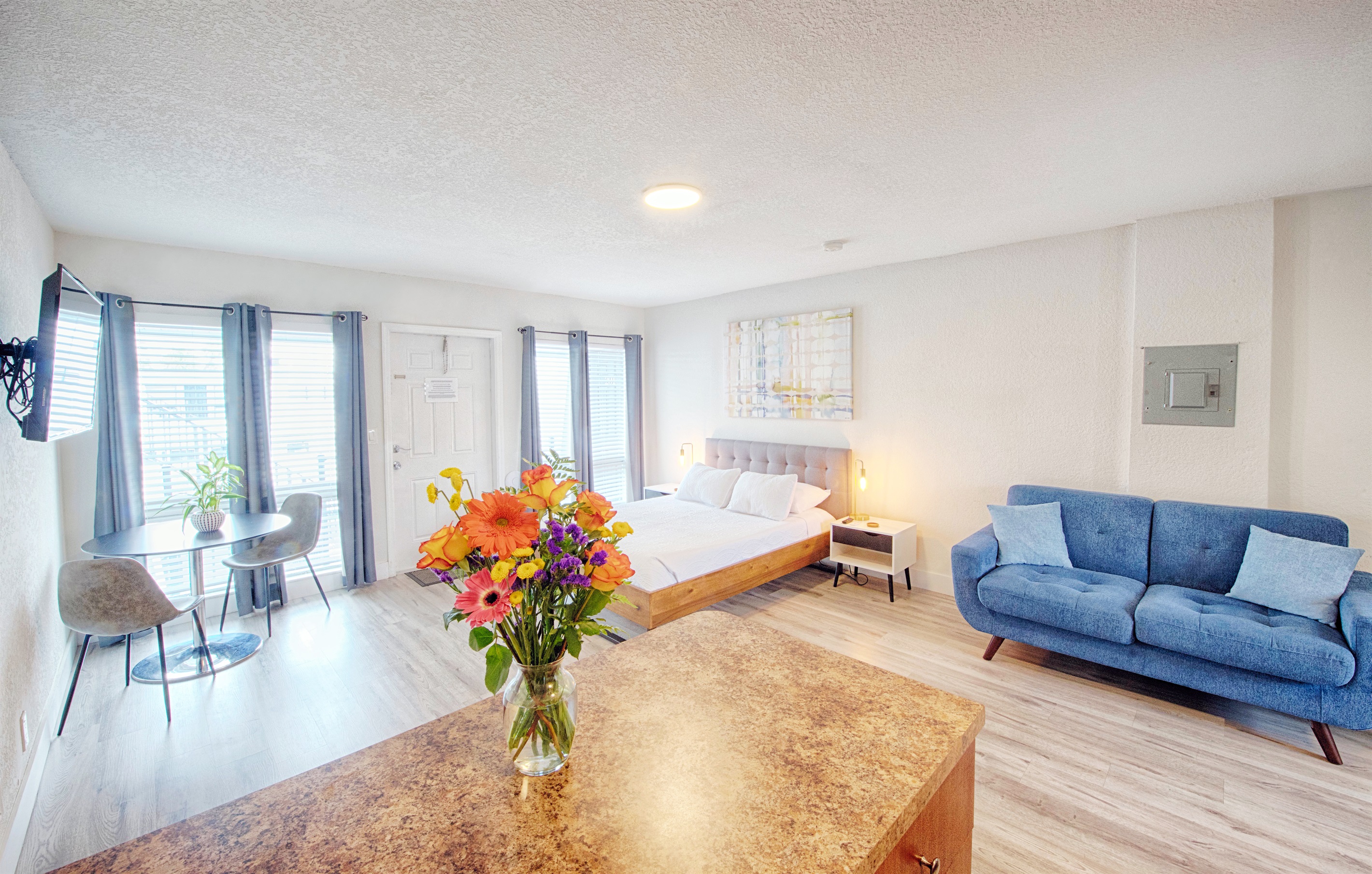 Alternative view of the bedroom facing apartment entry. Large windows include complete blackout curtains for privacy.