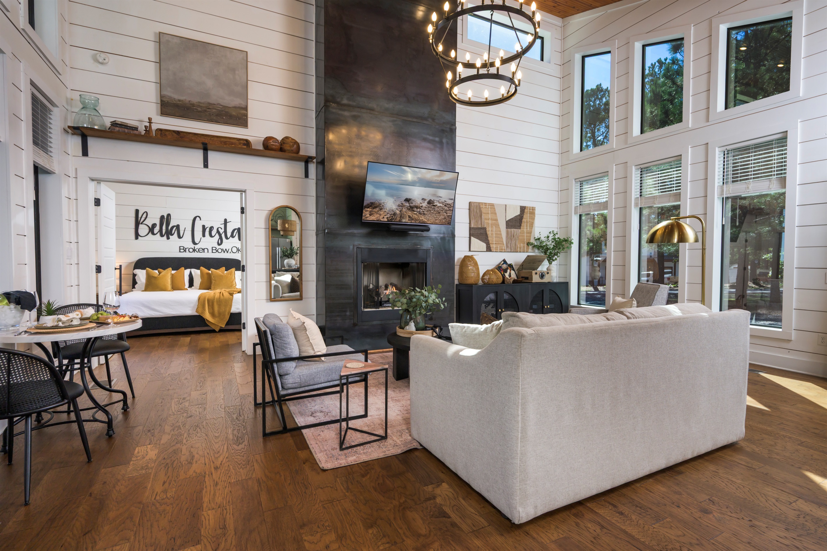 Modern luxury meets forest serenity — open-concept living with a grand fireplace and cozy bedroom steps away