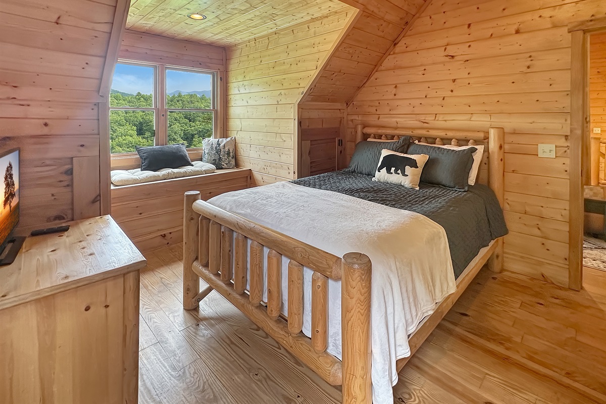 Experience mountain views from this charming log cabin bedroom with ample sunlight!