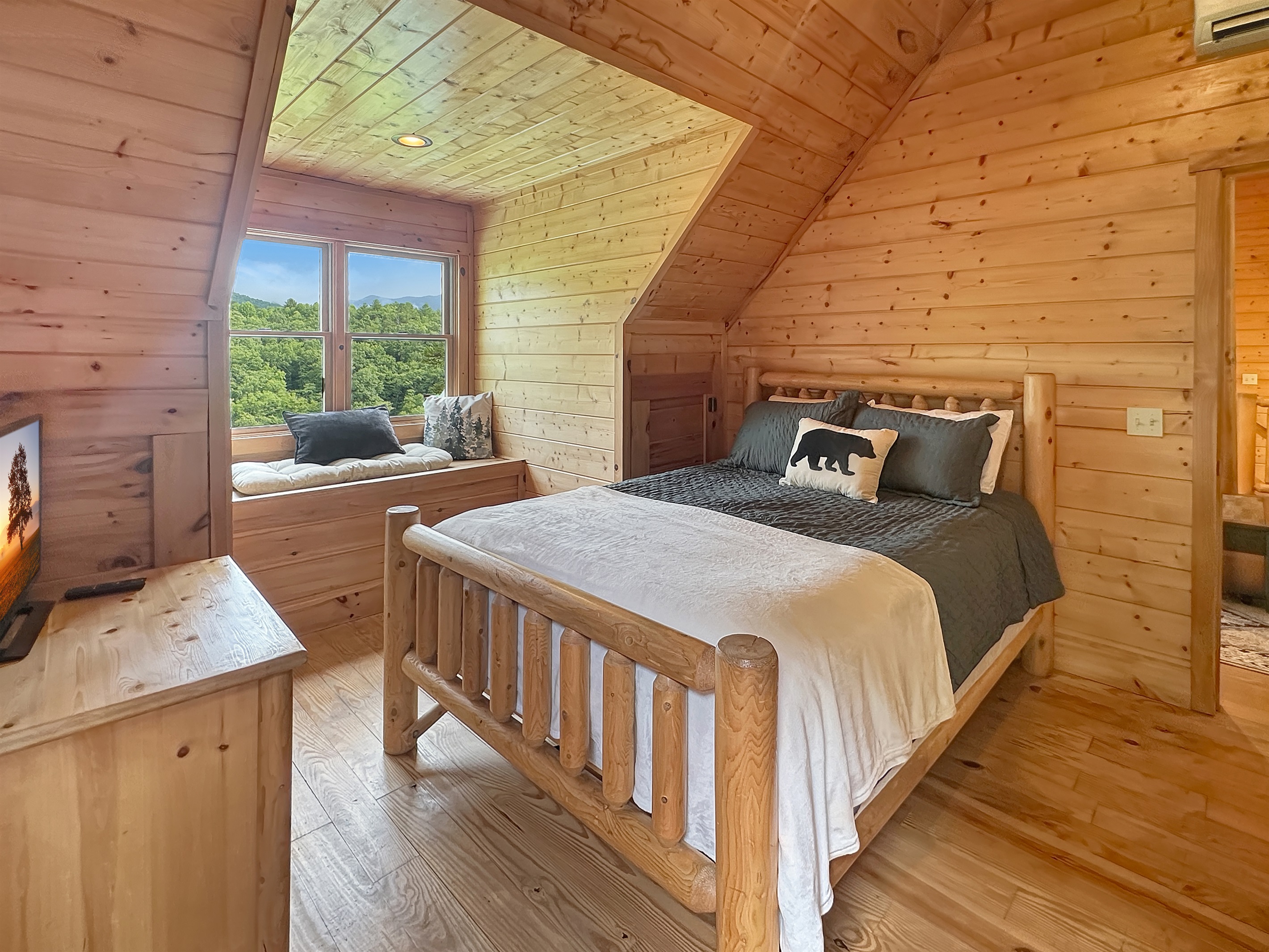 Experience mountain views from this charming log cabin bedroom with ample sunlight!