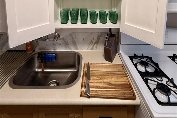 Plates and bowls for 4, sharp knives, and cutting boards. Full set of non-stick and non-toxic pots and pans.