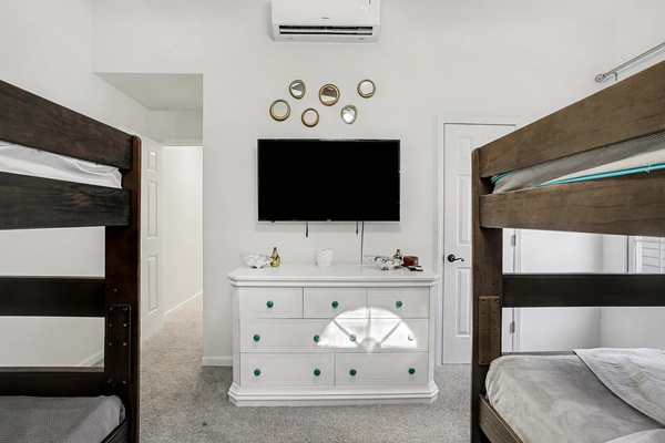 The bunk room has its own AC, smart TV, and dresser — teen approved