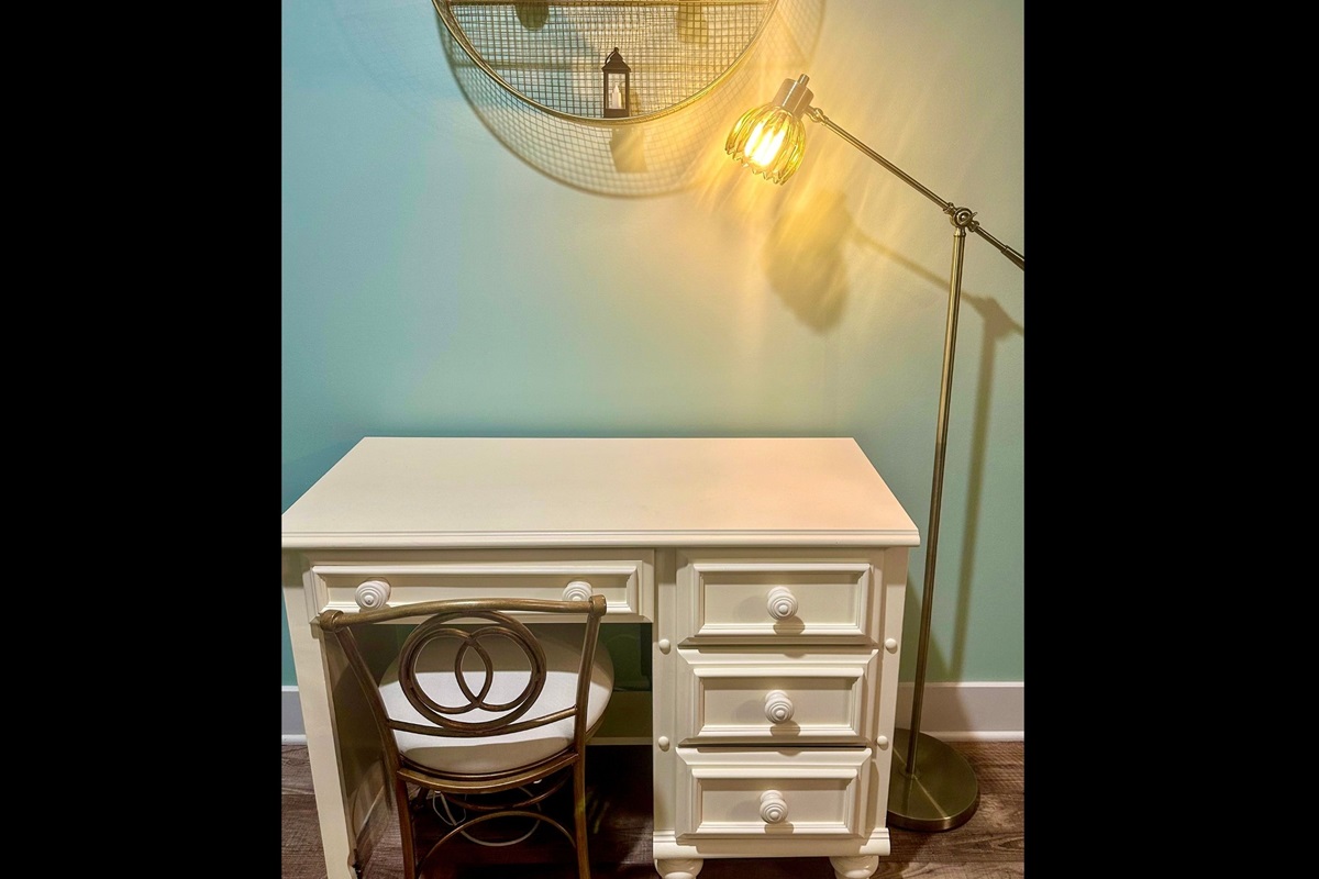 Living room workspace featuring a dedicated desk with task lamp, offering a comfortable spot for remote work or personal projects.