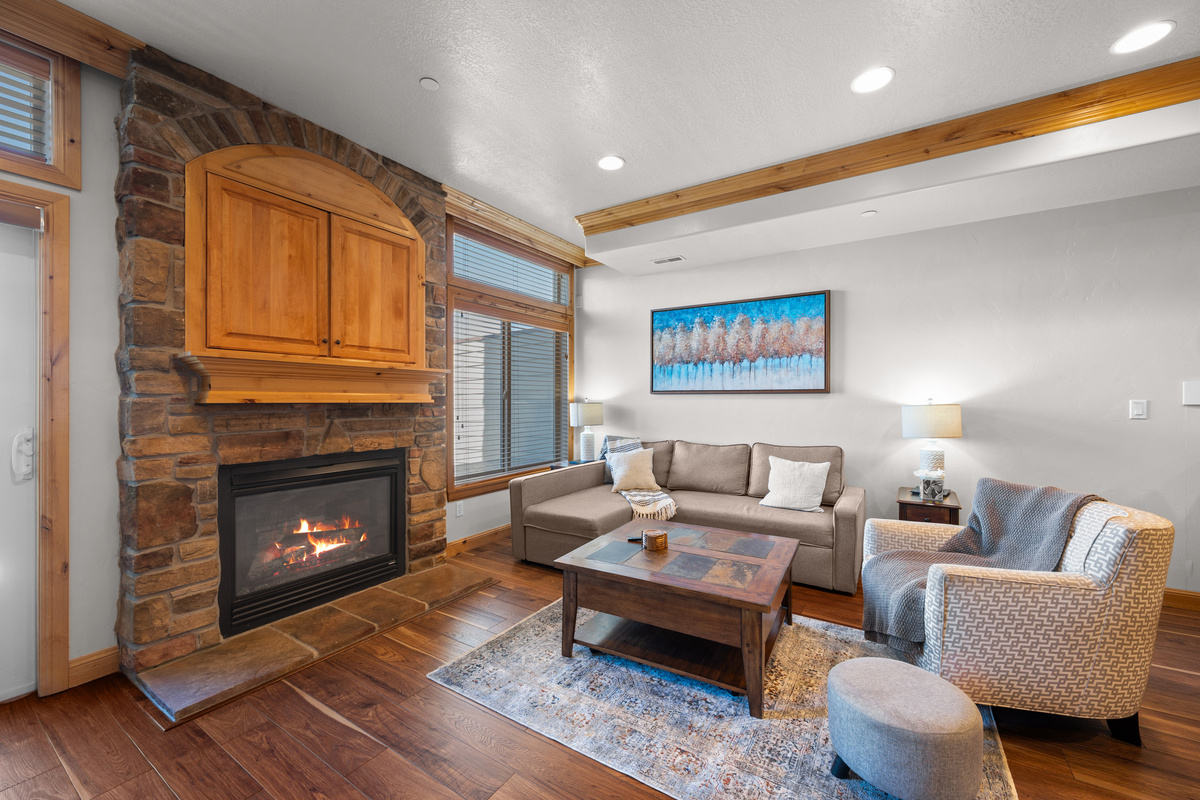 Warm mountain retreat with a stone fireplace and picturesque reservoir backdrop.