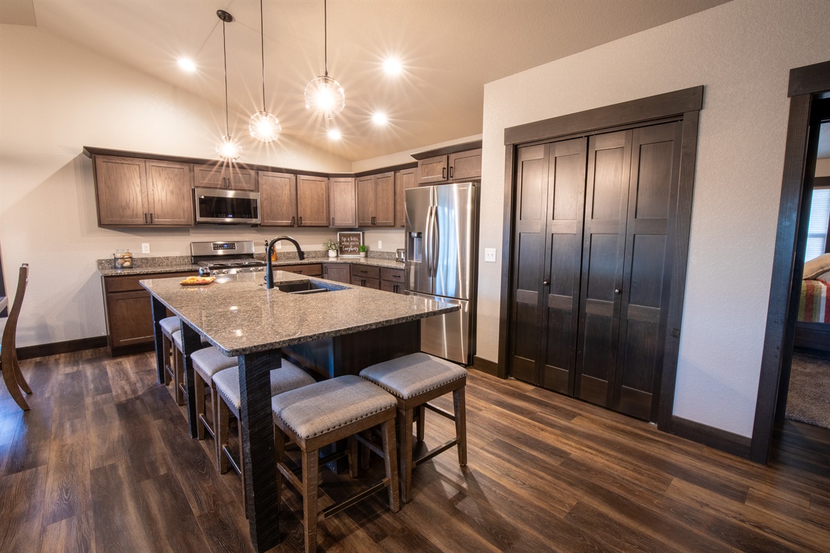 Picture yourself preparing meals in the sleek kitchen at "On The Rocks," surrounded by stainless steel appliances and a spacious granite island with bar stools. Envision gathering with loved ones for casual dining or lively chats.