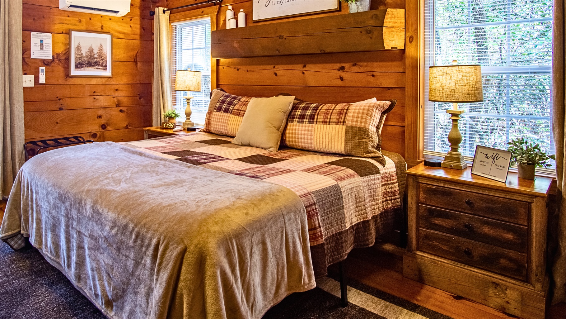 Cozy king bedroom with warm cabin charm, natural light, and peaceful views.