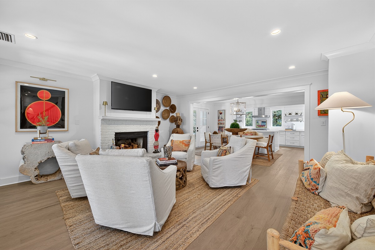 Light-filled living space with cozy seating, fireplace, and open flow into dining and kitchen—perfect for gathering and unwinding together