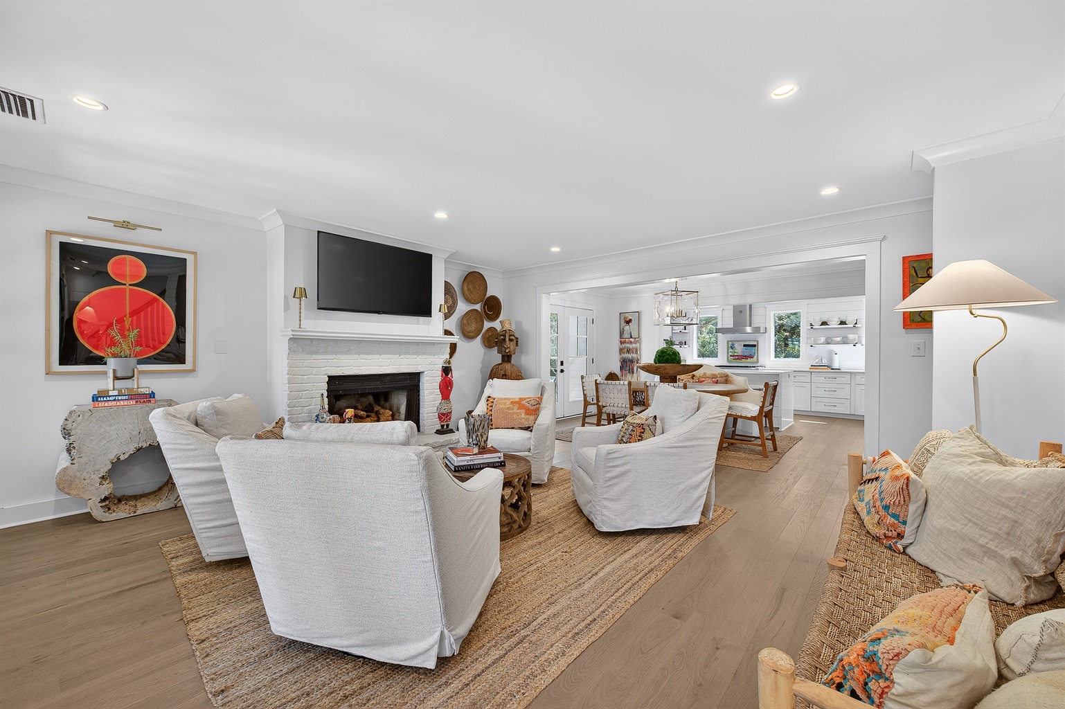 Light-filled living space with cozy seating, fireplace, and open flow into dining and kitchen—perfect for gathering and unwinding together