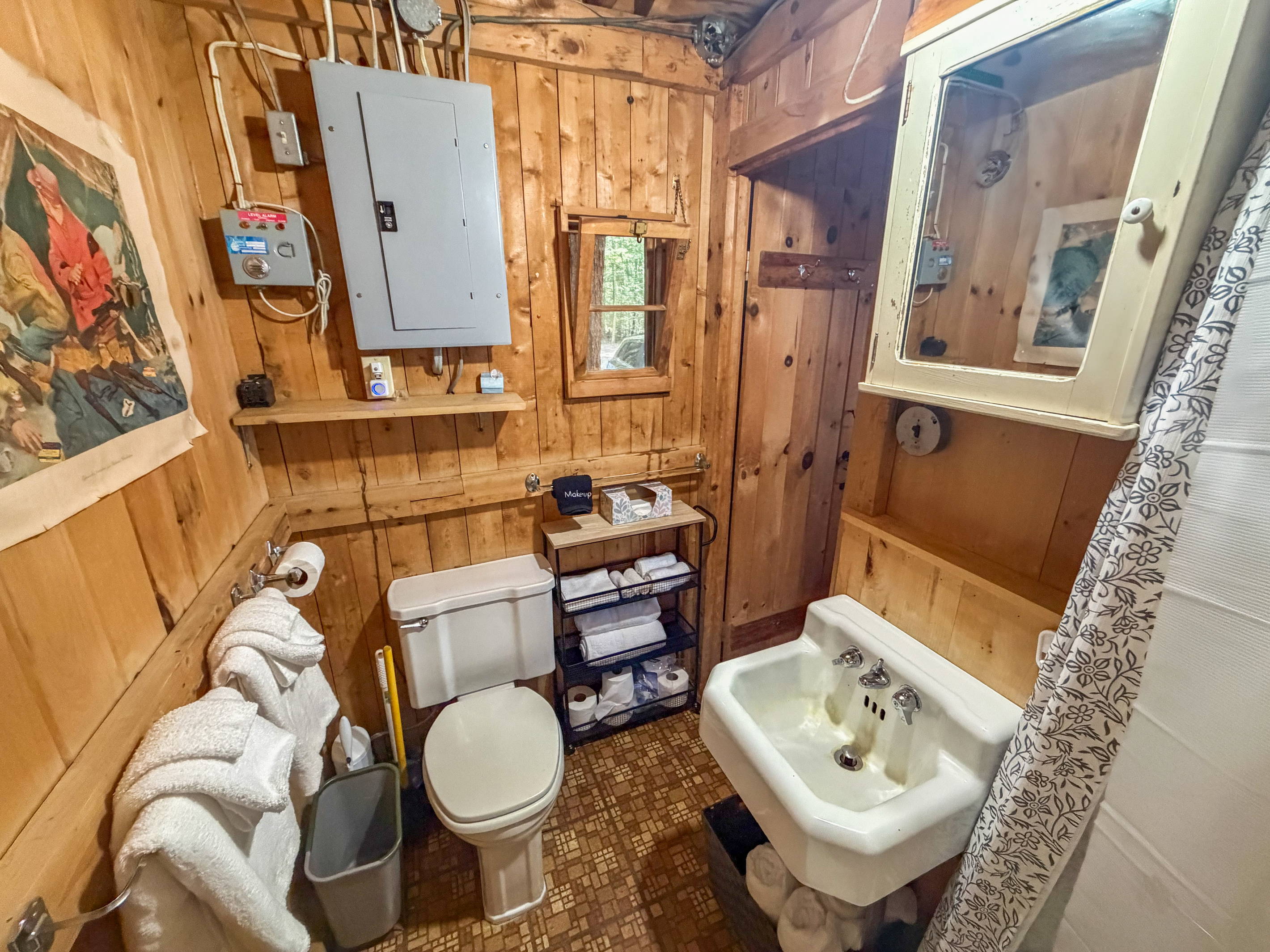 Bathroom details at Loonrise Point! Sink & plumbing run on lake-fed water (Primo dispenser in living room for drinking). Features medicine cabinet mirror, towel storage, & rustic pine charm on Beech Hill Pond in Otis, ME.