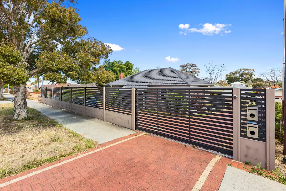 The secure front gate and paved entry introduce Sasha’s Cottage on the Hill before the home opens into private indoor and backyard spaces.