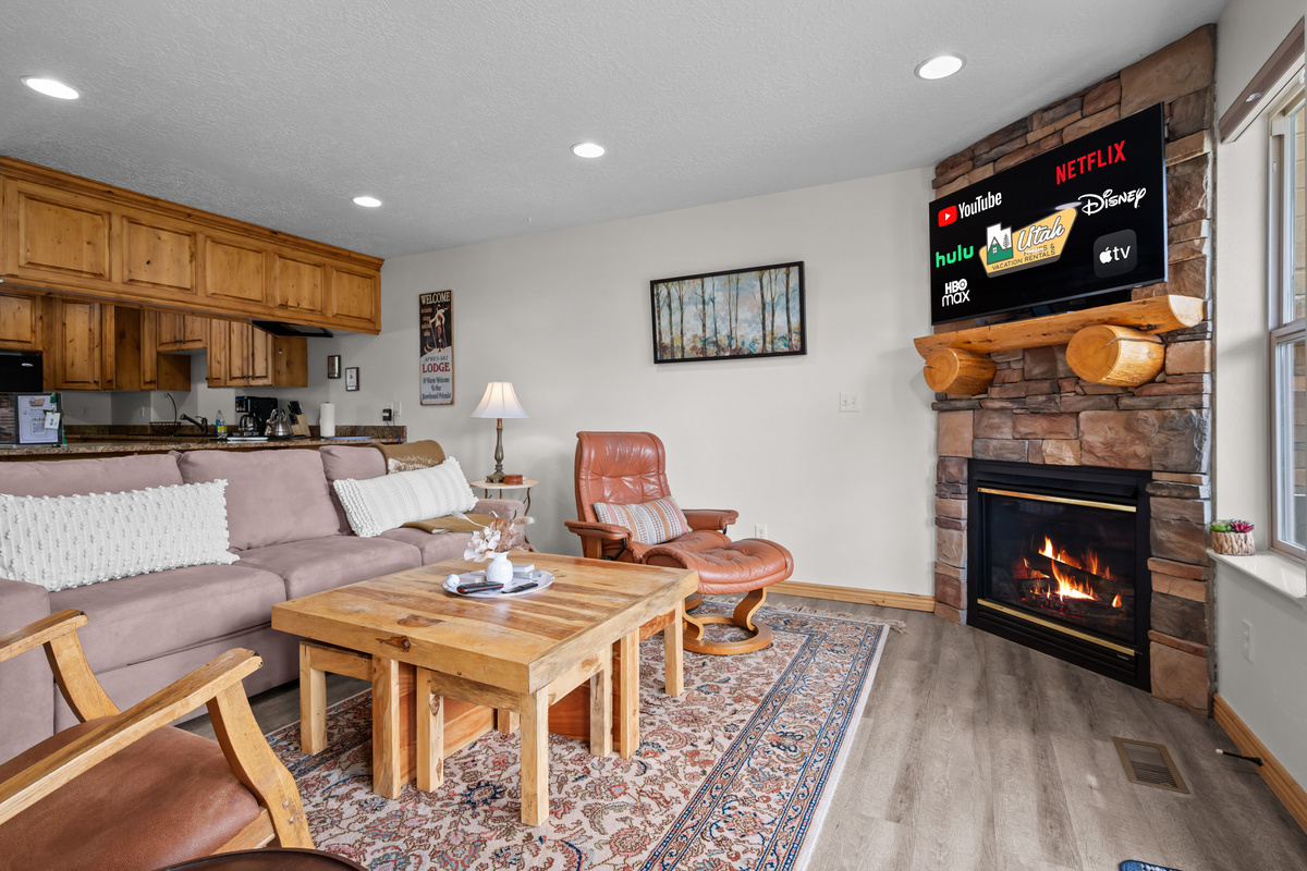 Open-concept layout featuring the cozy sleeper sofa, stylish kitchen, and dining area—all illuminated by soft recessed lighting.