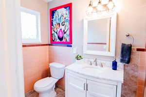 Modern Elegance: Sleek Toilet and Sink Area, Enhanced by a Tri-Lighted Mirror for Added Style and Functionality 🚽💡