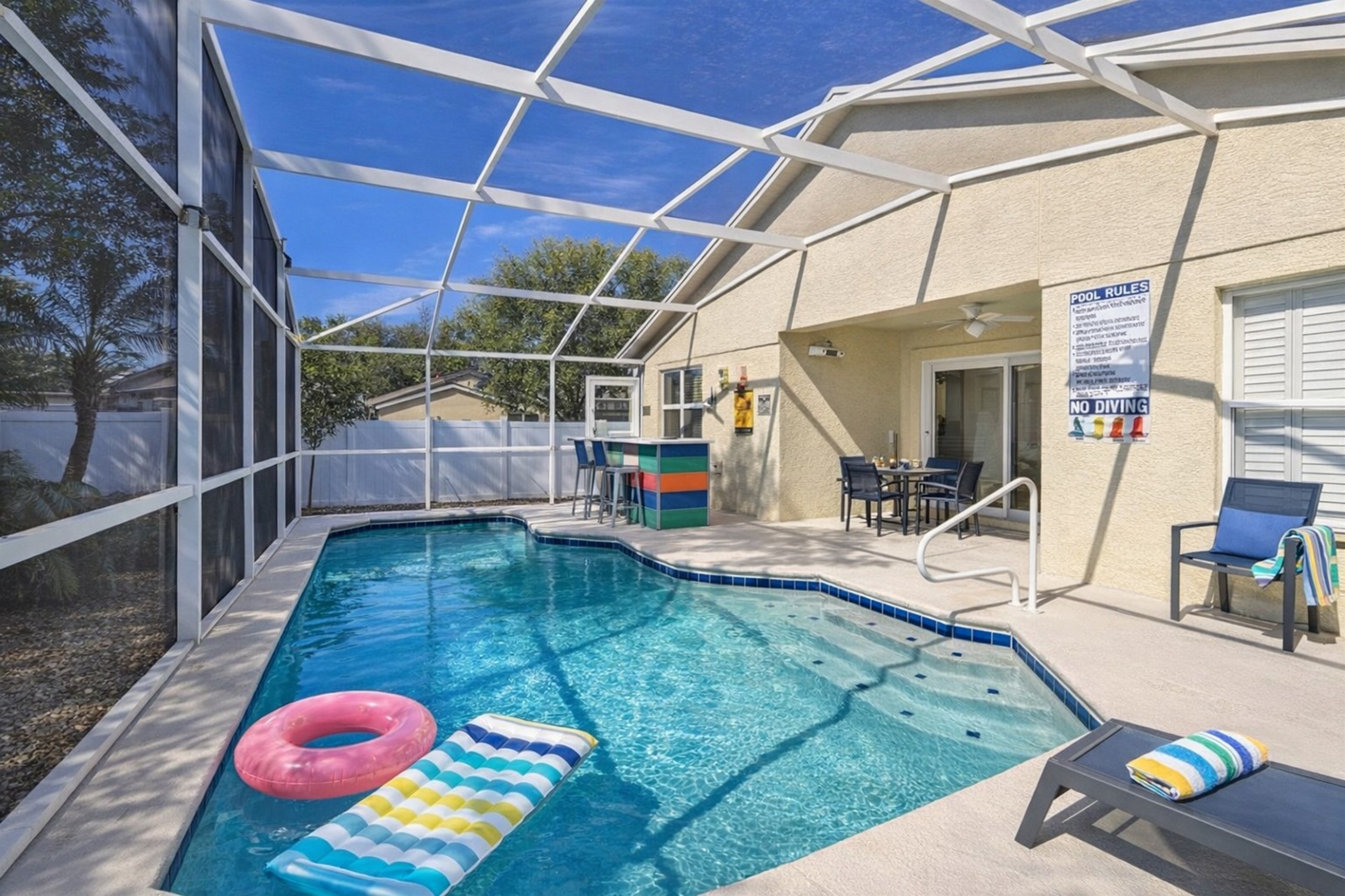 Enjoy movie nights by the pool in this modern screened outdoor space.