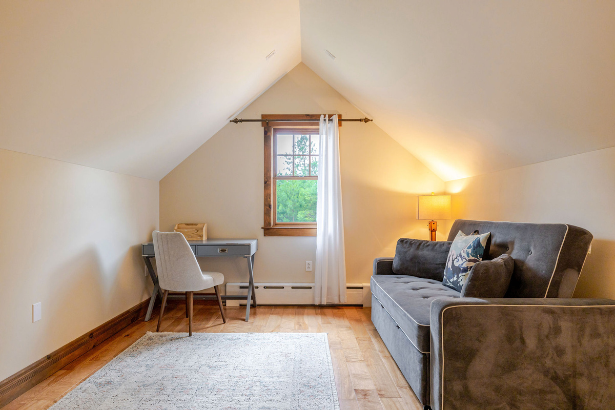 Spacious bedroom offers both sleeping, desk and chair, and lounging space with a queen-sized sleeper sofa.