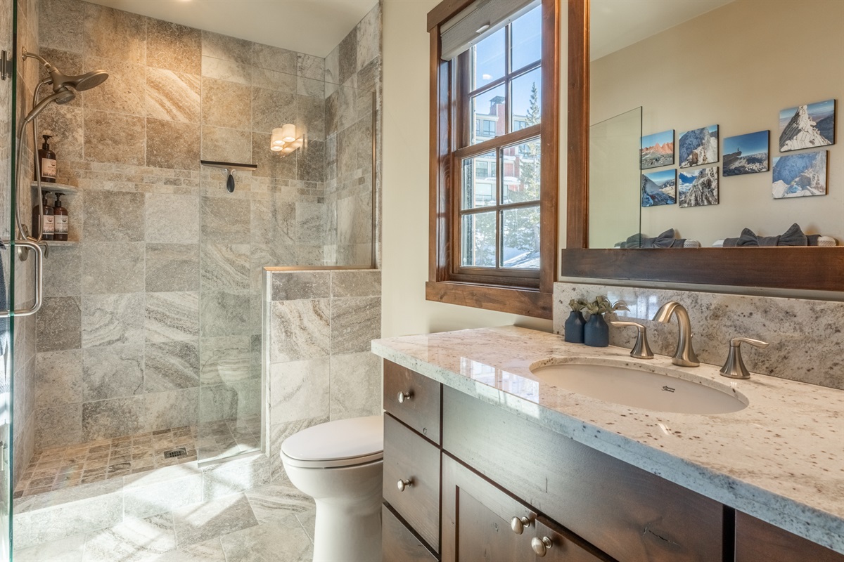 The second primary bath features a sleek walk-in shower and smart design touches—proving that functionality doesn’t have to sacrifice style.