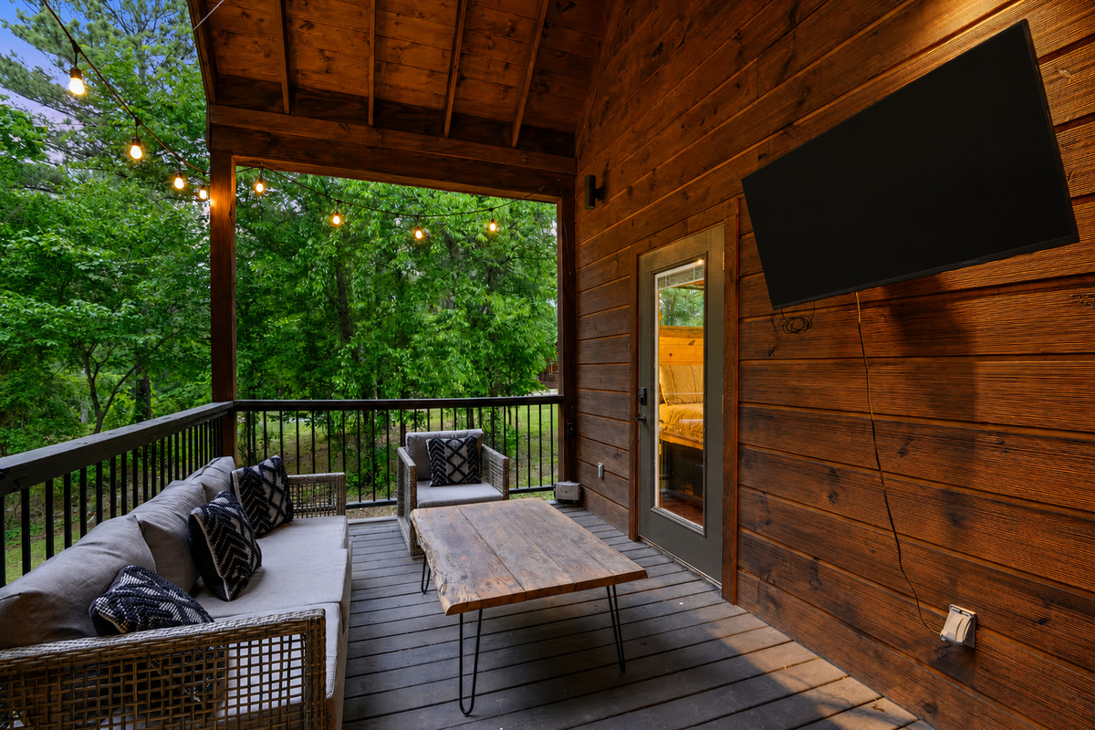 Porch Paradise: Unwind on a stylish deck, surrounded by nature and twinkling lights!