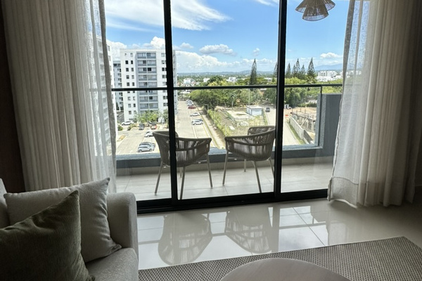 Floor-to-ceiling glass doors frame beautiful views of Santiago and the mountains beyond. 🇩🇴⛰️