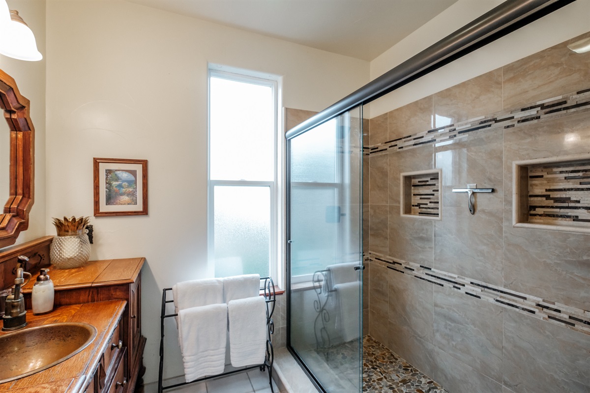 Amazing vintage dresser vanity with double rainhead shower, sliced pebble floor and double sink vanity