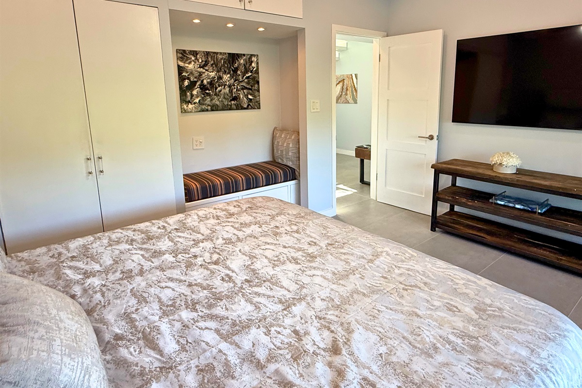 This guest room has a Smart TV, ceiling fan and little seating nook