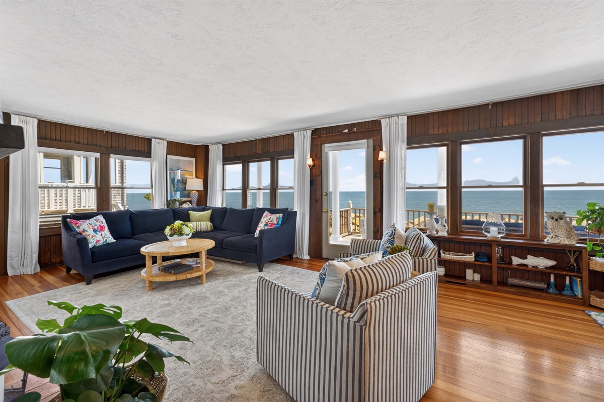 Bright coastal living space with panoramic ocean views, cozy seating, and direct access to the private deck, perfect for relaxing to the sound of the waves. 🌊