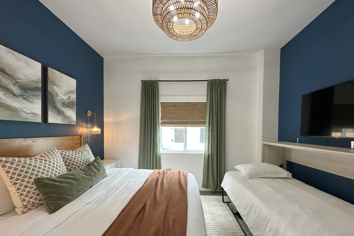 A built-in twin Murphy bed folds down in this room — a real mattress, not a fold-out — so the kids get their own spot without losing floor space.