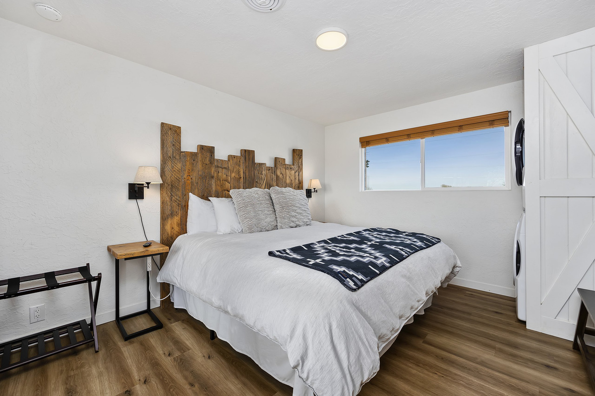 King bedroom with a handcrafted barn-wood headboard and farm-country views