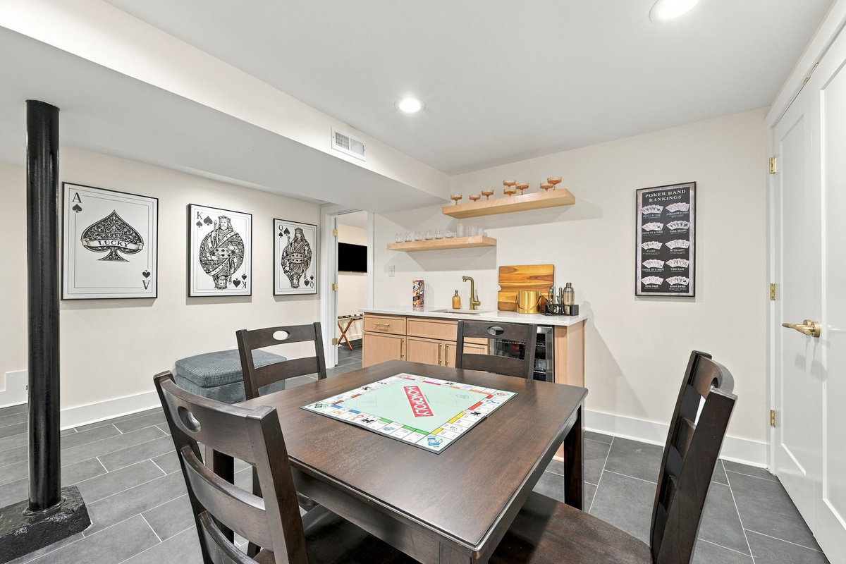 Game Room Retreat: Enjoy playful evenings in this stylish games room with a sleek bar and art decor!