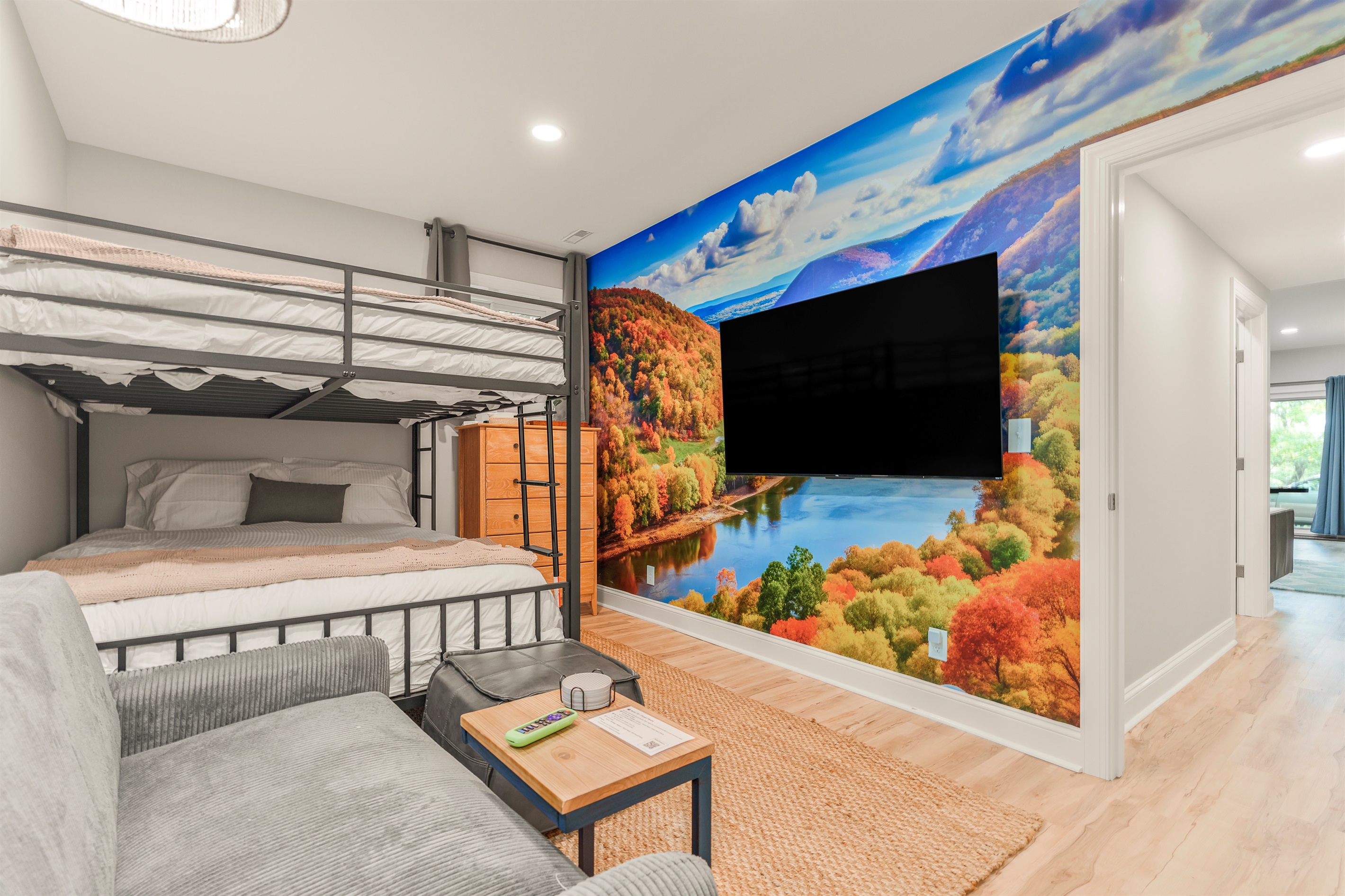 A vibrant nod to the Shenandoah—this queen bunk room brings color, comfort, and fun. Featuring a full-wall mural, cozy loveseat, 65” TV, and quick access to the bath next door