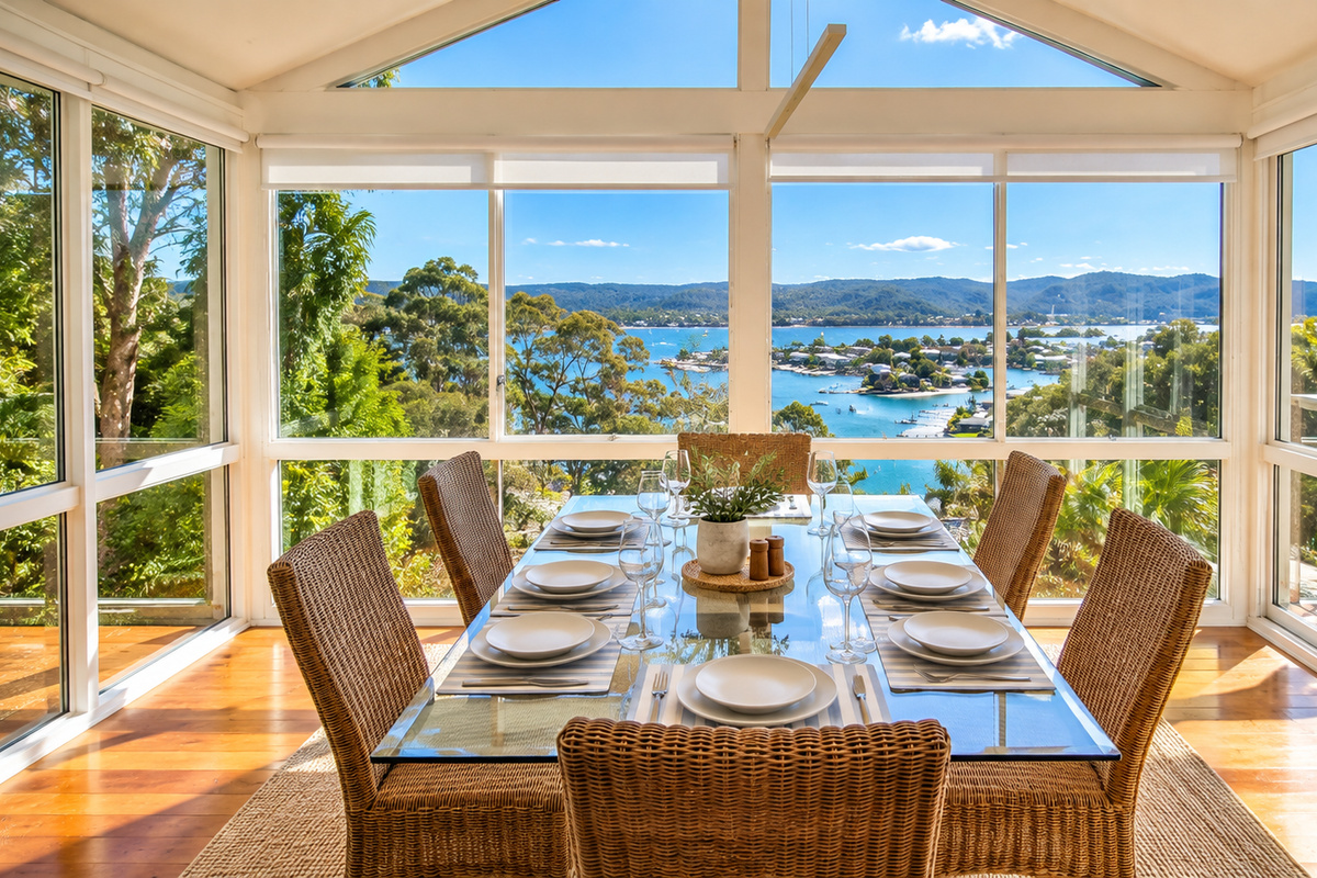 Surrounded by floor-to-ceiling windows, this inviting dining area brings the breathtaking coastal scenery indoors.