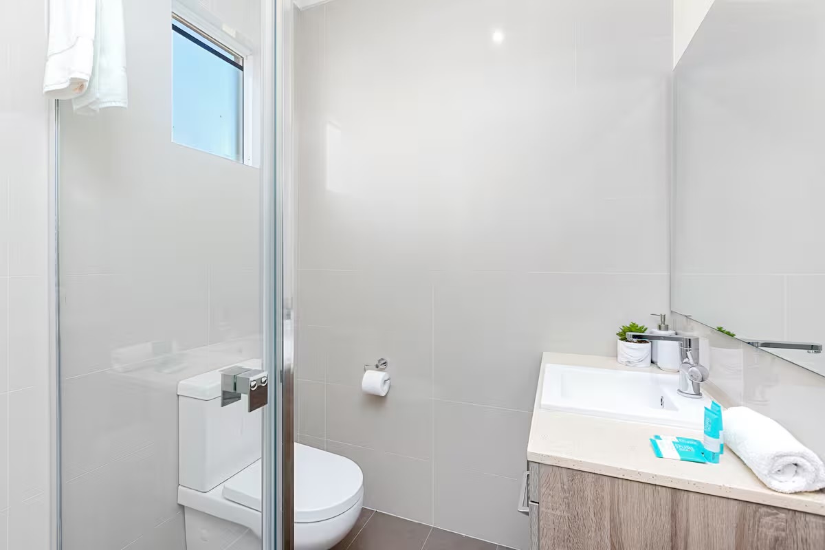 Clean white finishes and a practical vanity layout give this bathroom detail at Sasha’s Cottage on the Hill a fresh, easy-care feel.