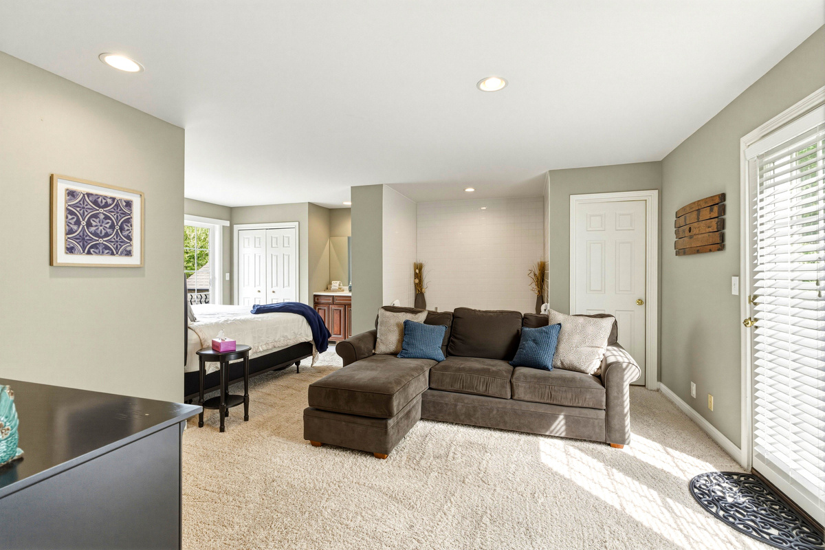 2nd floor master with jacuzzi tub and small living room with couch and balcony