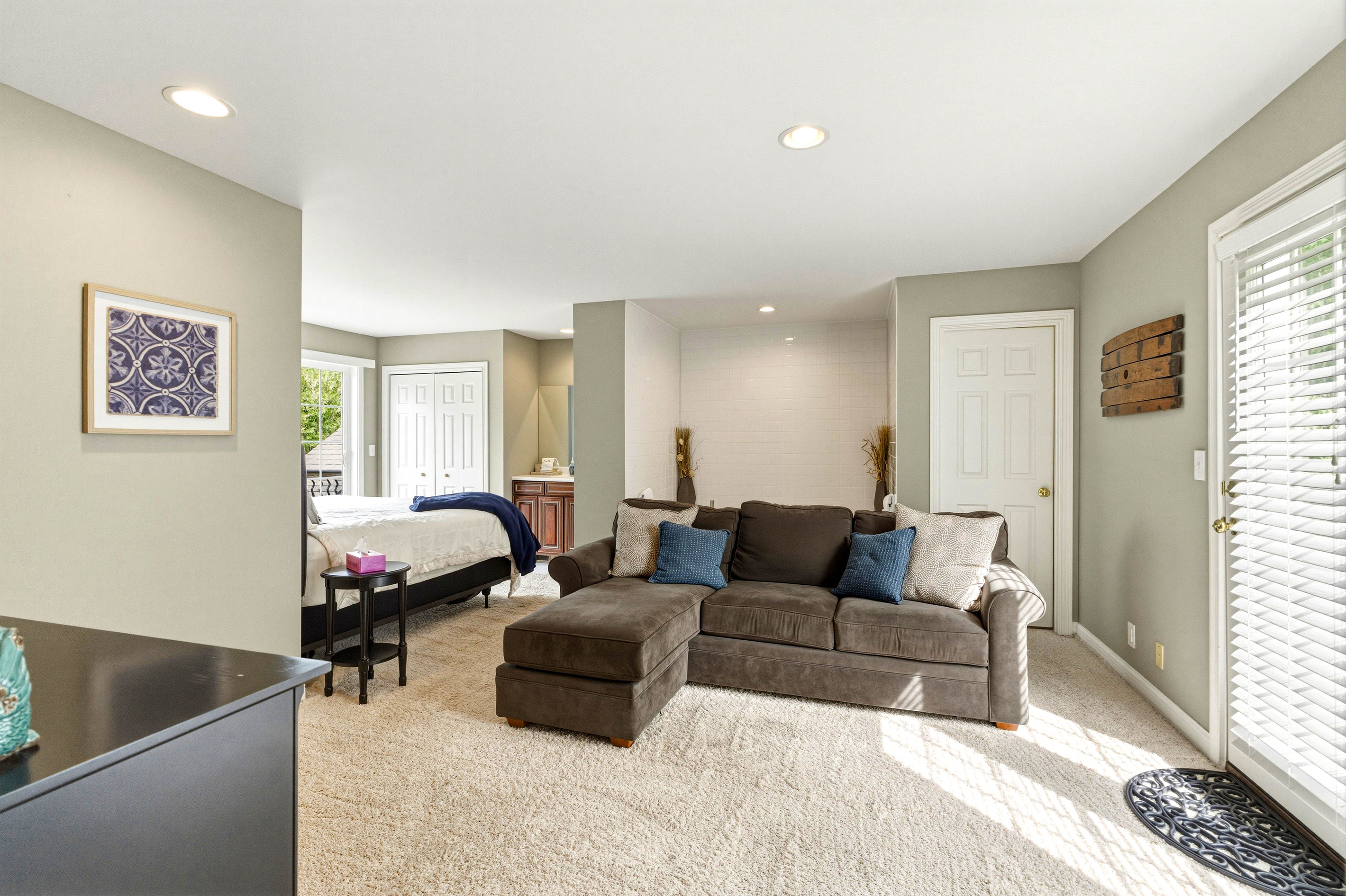 2nd floor master with jacuzzi tub and small living room with couch and balcony