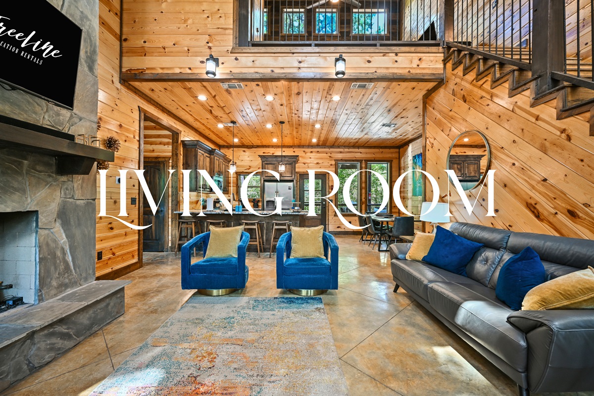 The open living room offers warmth and comfort with its wood finishes, cozy seating, and double-height windows that let the forest in.