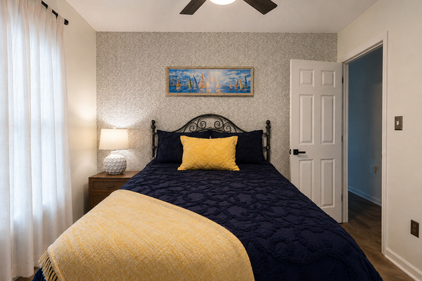 Comfortable queen bedroom on the main level with bedside lighting, closet access and a calm, restful feel.