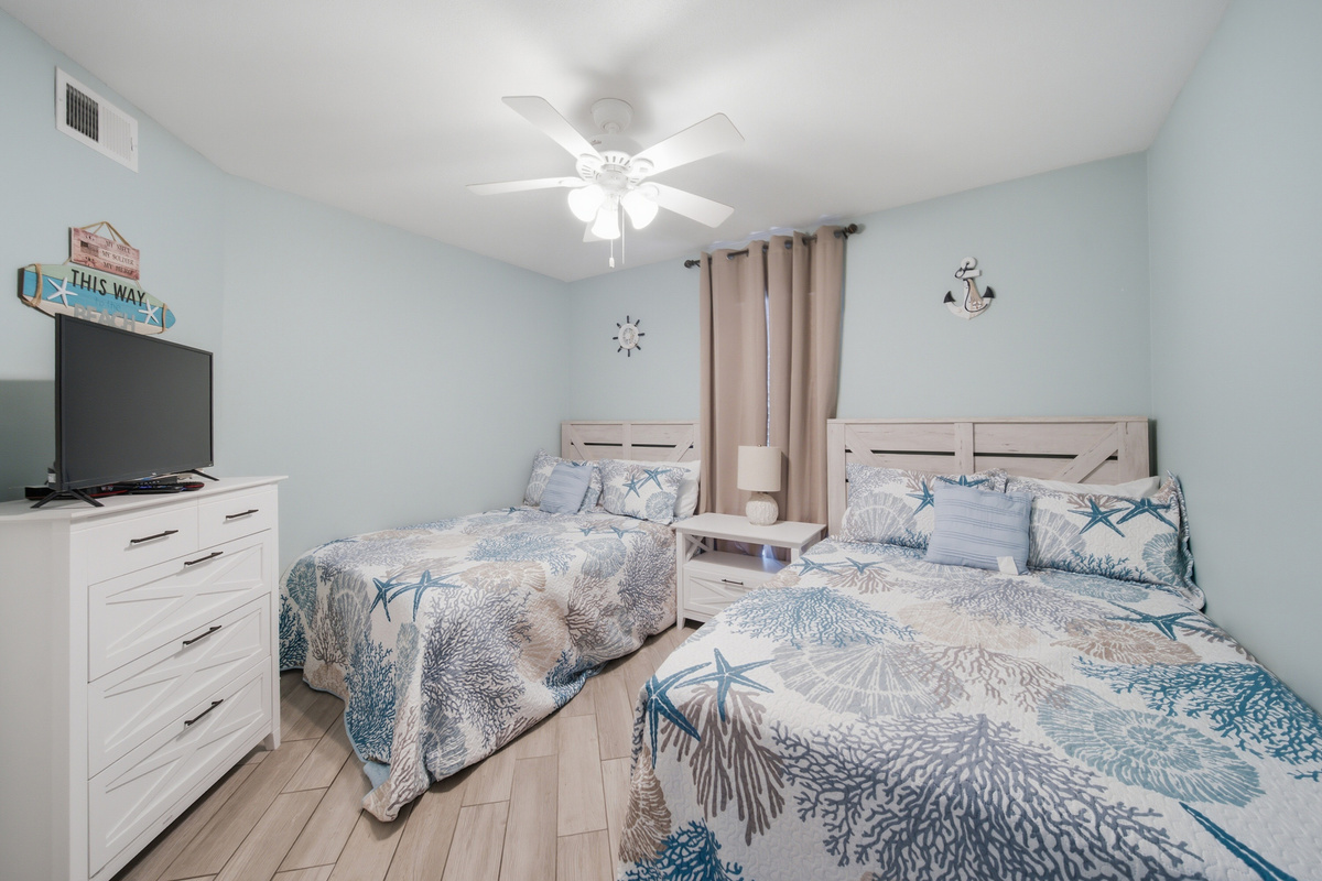 Second bedroom with two full beds and a mounted TV, perfect for kids or friends