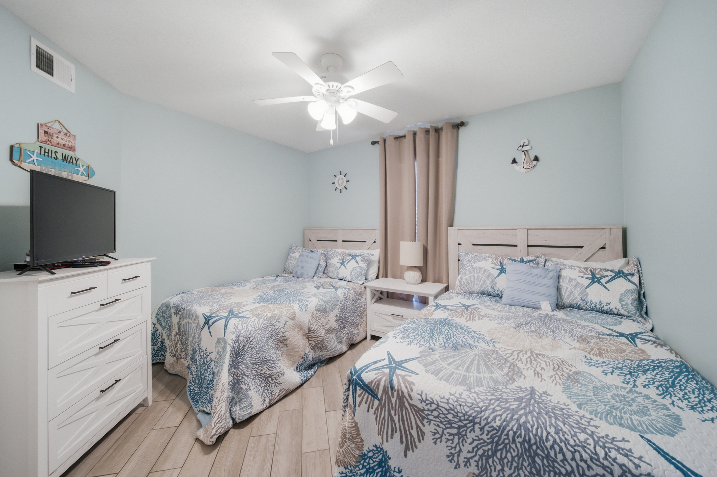 Second bedroom with two full beds and a mounted TV, perfect for kids or friends