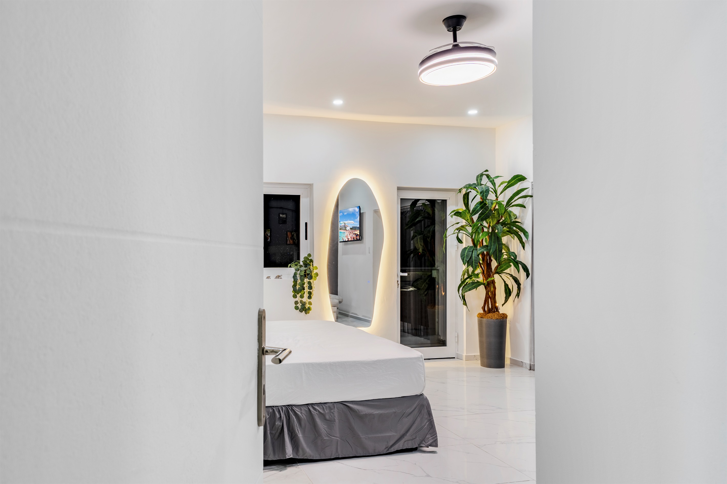 View into the primary suite from the doorway, featuring the LED mirror and sliding door