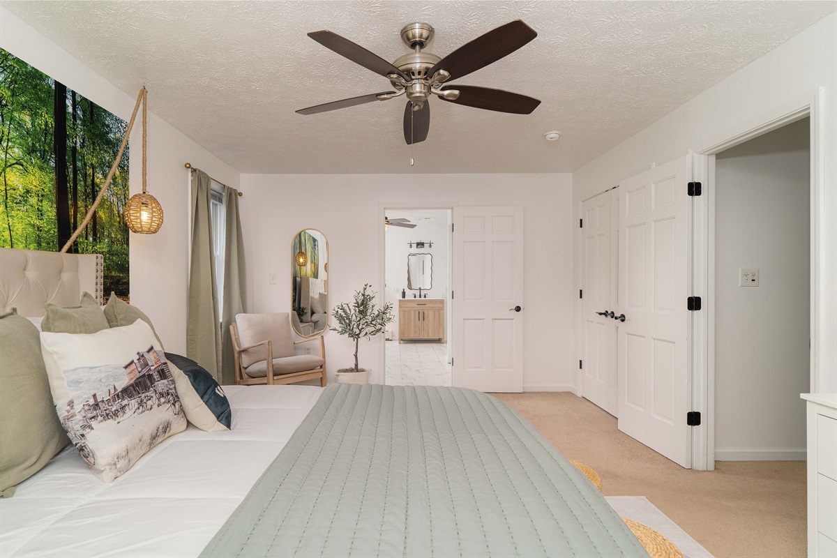 Primary suite with dedicated sitting nook, dresser storage, and direct access to the large ensuite bathroom.