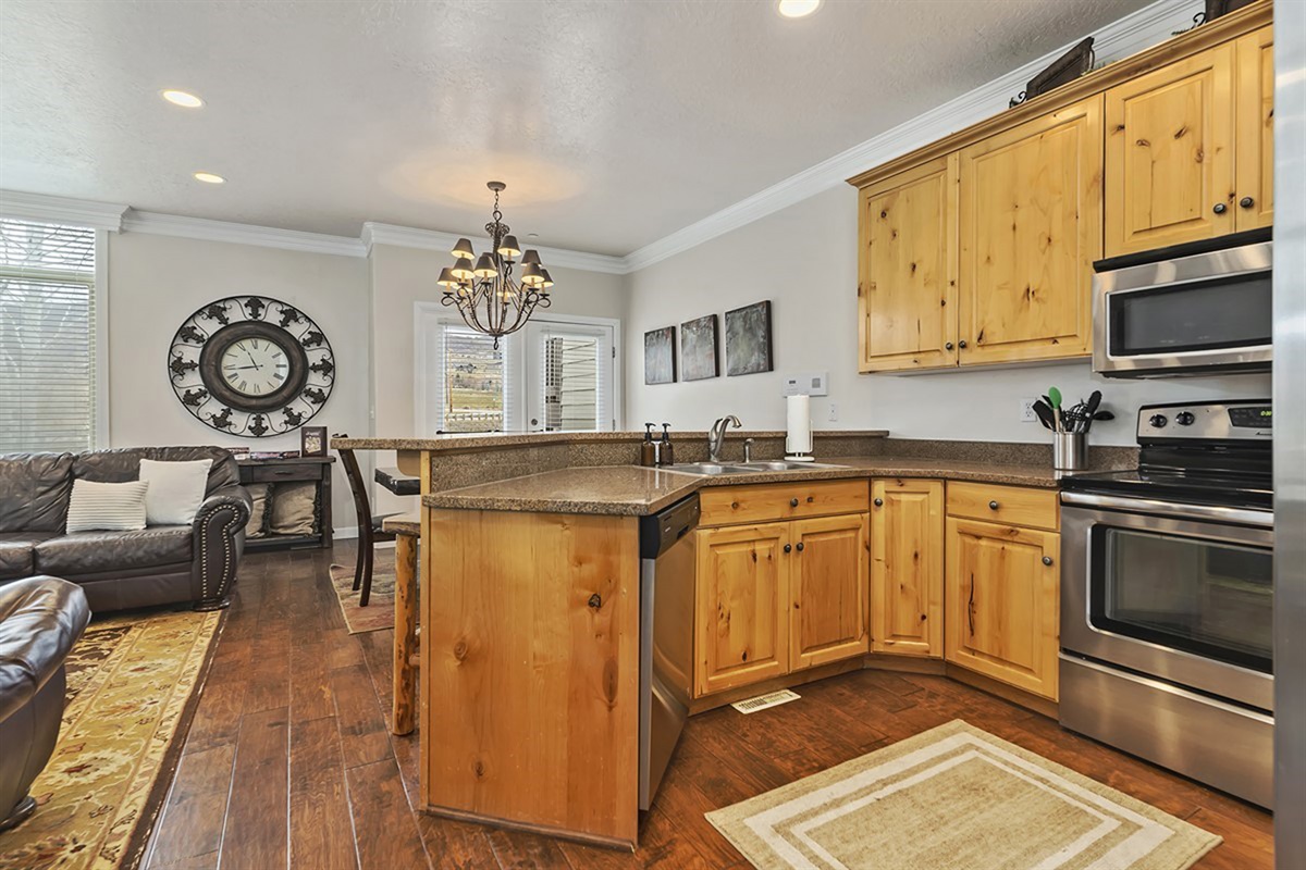 A fully equipped kitchen featuring granite countertops, modern appliances, and warm wood cabinetry—crafted for both convenience and style.
