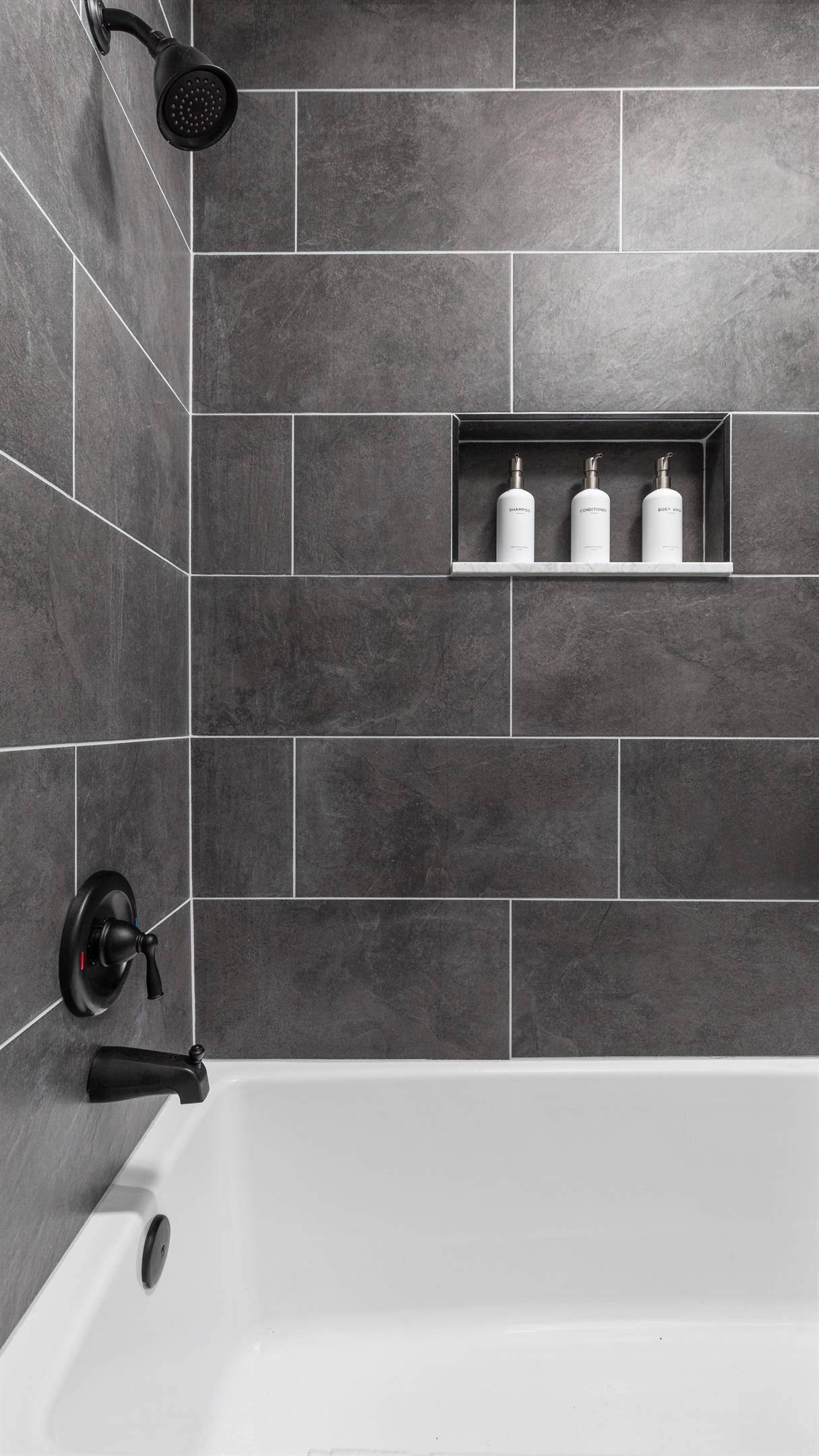 Bathroom with full tub—shampoo, conditioner, and body wash provided for your comfort.