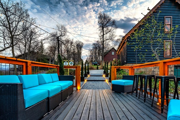 Scenic hangout deck (deck area #2) on the side of the house featuring sweeping mountain views, bar table and a colorful sunset, creating the perfect space for relaxation and memorable moments.