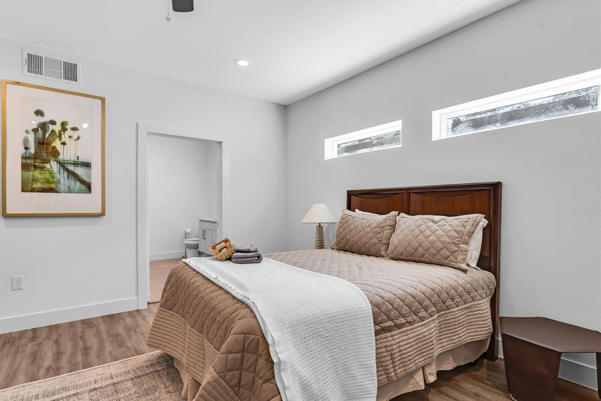 Unwind in the cozy primary bedroom with ensuite bath, luxury linens, and smart TV.