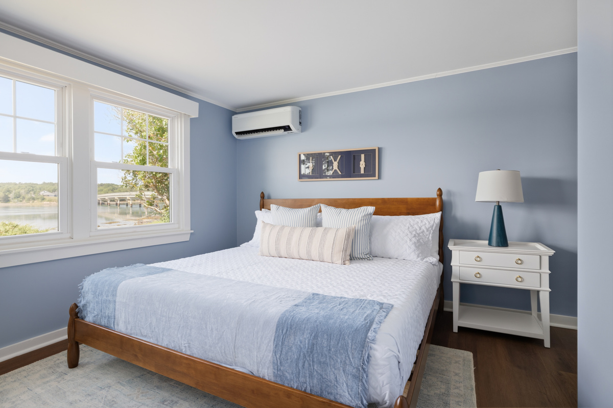 The master suite has room to spread out properly — seating area, king bed, private ensuite two steps away, water outside every window.